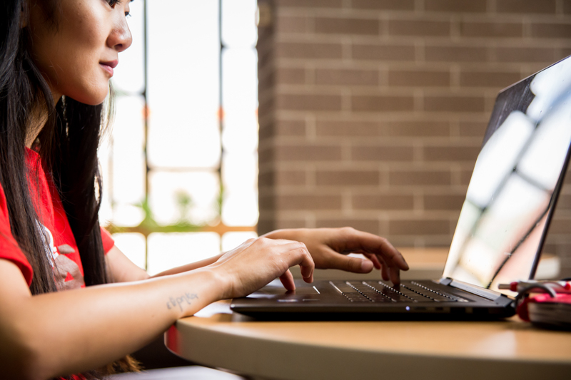 student typing on computer